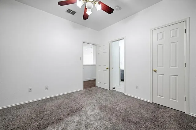an empty room with chandelier fan
