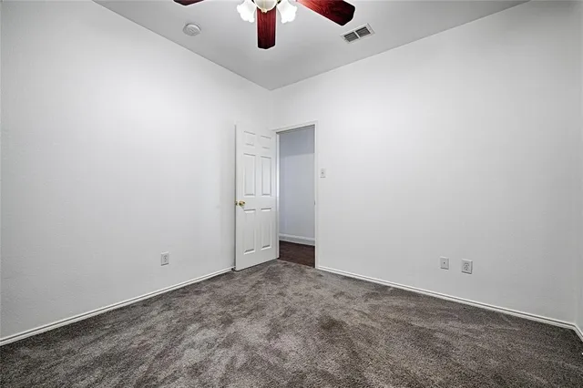an empty room with a ceiling fan and a window