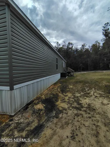 a view of a backyard with table and chairs under an umbrella