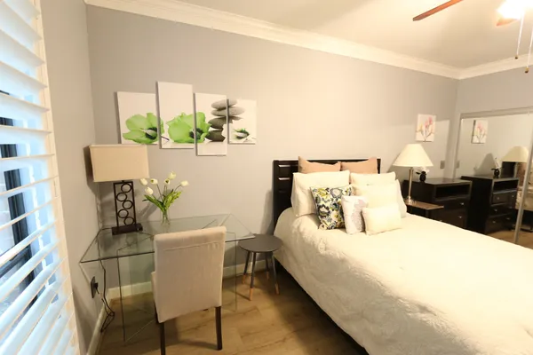 a bedroom with a bed table and chair