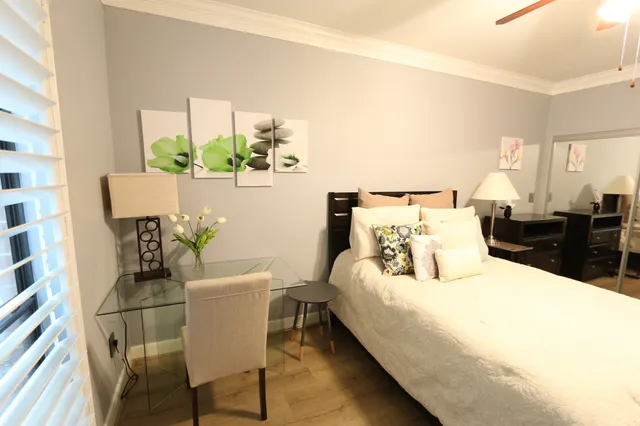 a bedroom with a bed table and chair