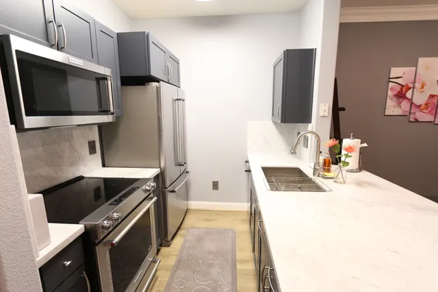 a kitchen with stainless steel appliances a stove microwave and sink