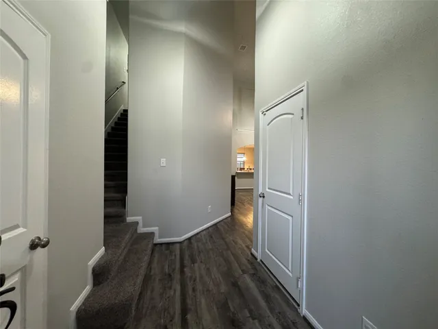 a view of a hallway with wooden floor and staircase