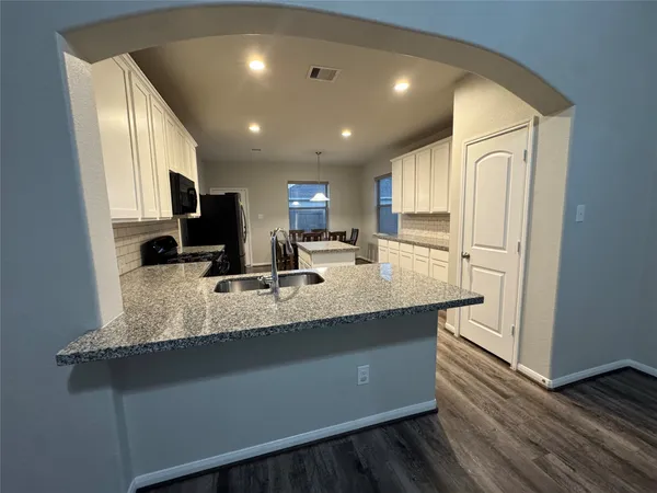 a kitchen with stainless steel appliances granite countertop a sink refrigerator and cabinets