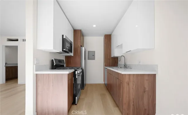 a kitchen with a sink stove top oven and refrigerator