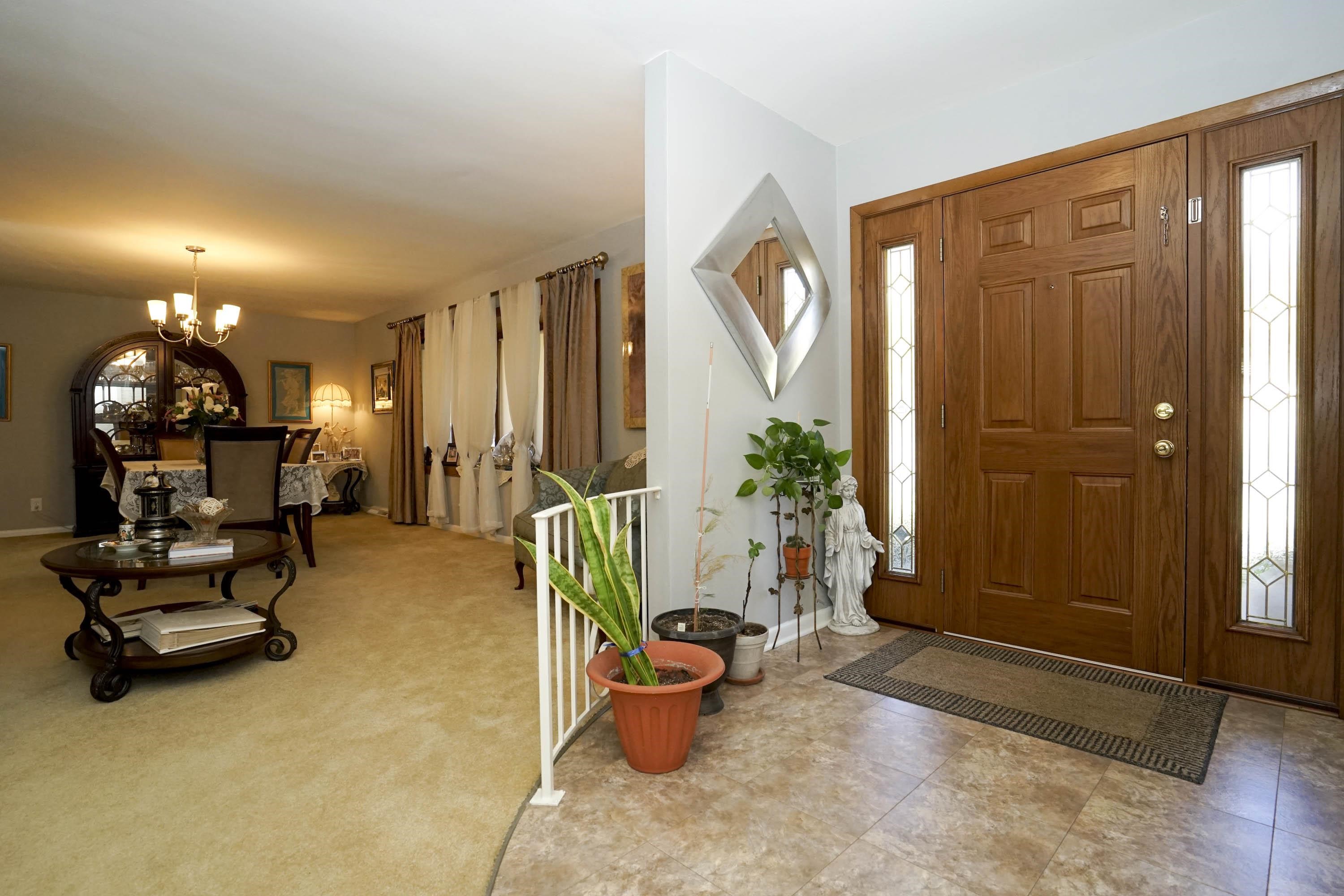 2707 Spring Creek Road Rockford, IL 61107 - Photo 5 of 44 a room with lots of white furniture and a potted plant