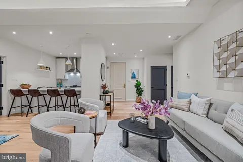 a living room with furniture a potted plant and a table