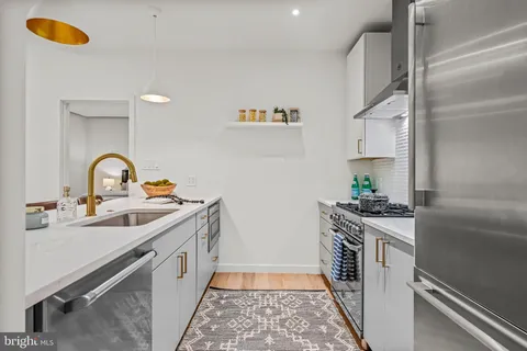a kitchen with a sink a stove and cabinets