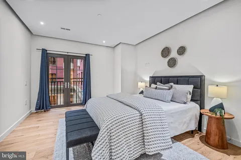 a bedroom with a bed and a refrigerator