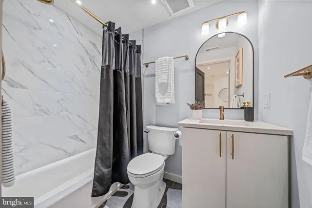 a bathroom with a shower a toilet and a tub