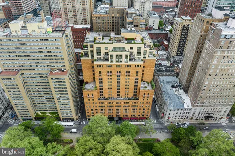 a living room with furniture fireplace and large windows