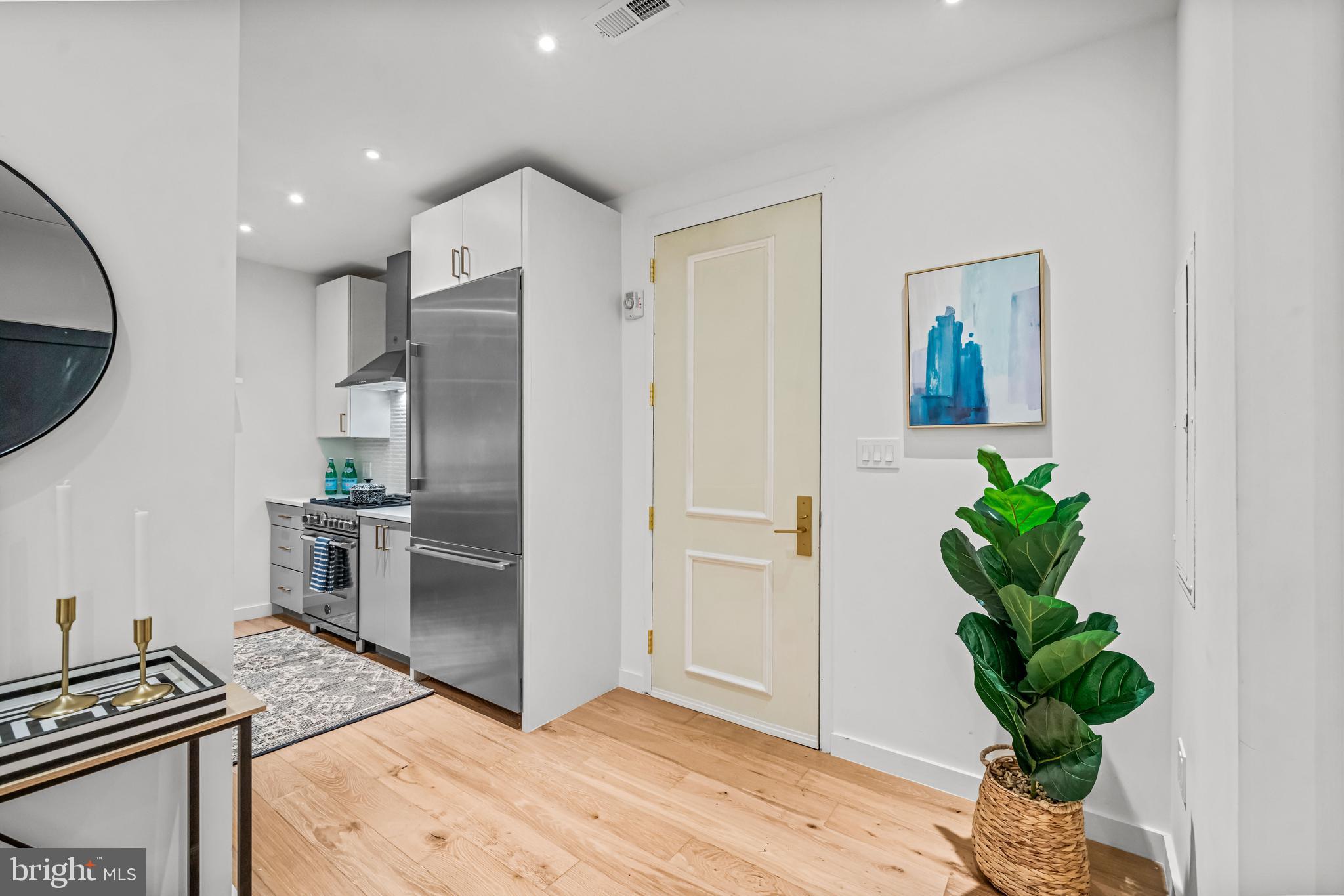 219 South 18th Street, Unit 309 Philadelphia, PA 19103 - Photo 9 of 44 a kitchen with stainless steel appliances granite countertop a refrigerator a stove and a wooden floor