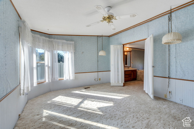 12958 South 300 East Draper, UT 84020 - Photo 34 of 38 Unfurnished bedroom with ornamental molding, a ceiling fan, carpet floors, wallpapered walls, and a wainscoted wall