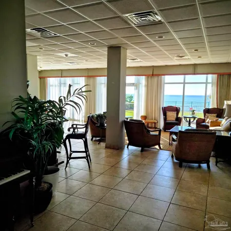 a living room with furniture and large windows