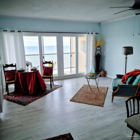 a living room with furniture large window and a wooden floor