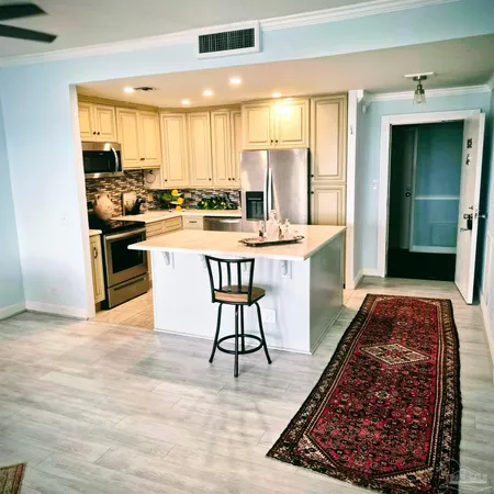 a kitchen with stainless steel appliances granite countertop a stove top oven a sink a dining table and chairs