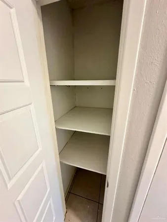 a view of walk in closet with empty racks