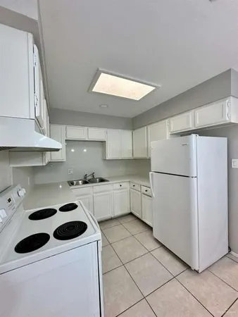 a kitchen with a white stove top oven and white cabinets