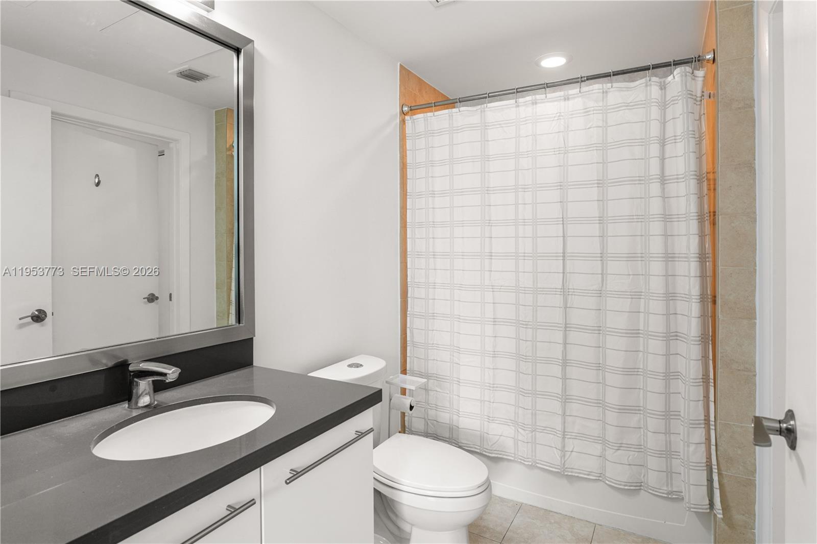 90 Southwest 3rd Street, Unit 1115 Miami, FL 33130 - Photo 12 of 17 a bathroom with a granite countertop sink toilet a mirror a shower and a mirror