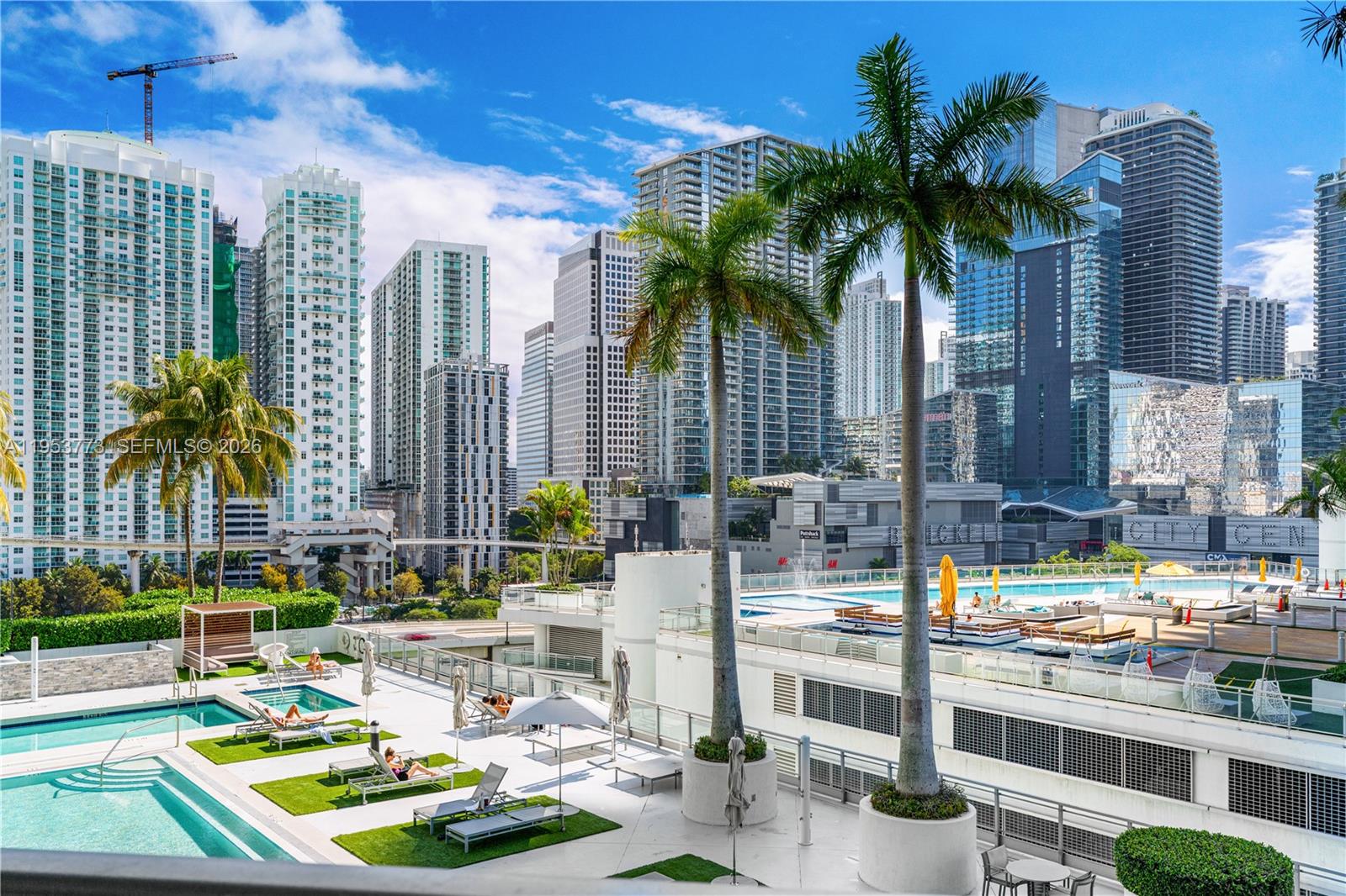90 Southwest 3rd Street, Unit 1115 Miami, FL 33130 - Photo 17 of 17 a view of a swimming pool with a lawn chairs and palm tree