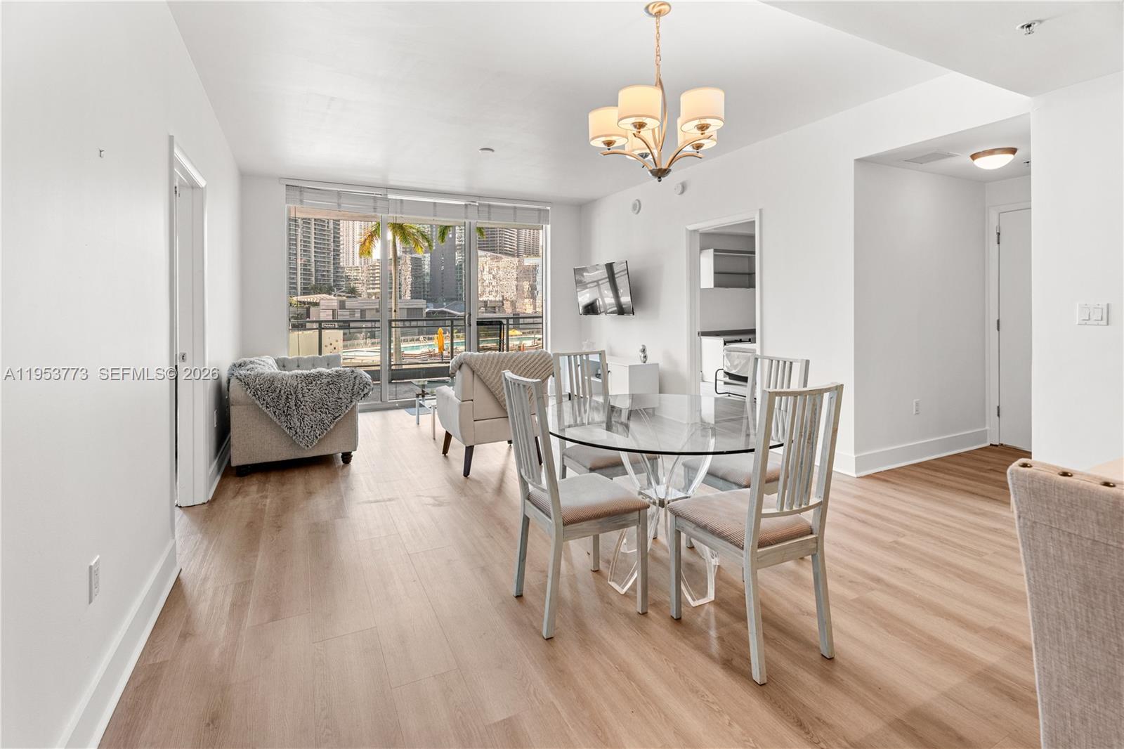 90 Southwest 3rd Street, Unit 1115 Miami, FL 33130 - Photo 2 of 17 a view of a dining room with furniture and wooden floor