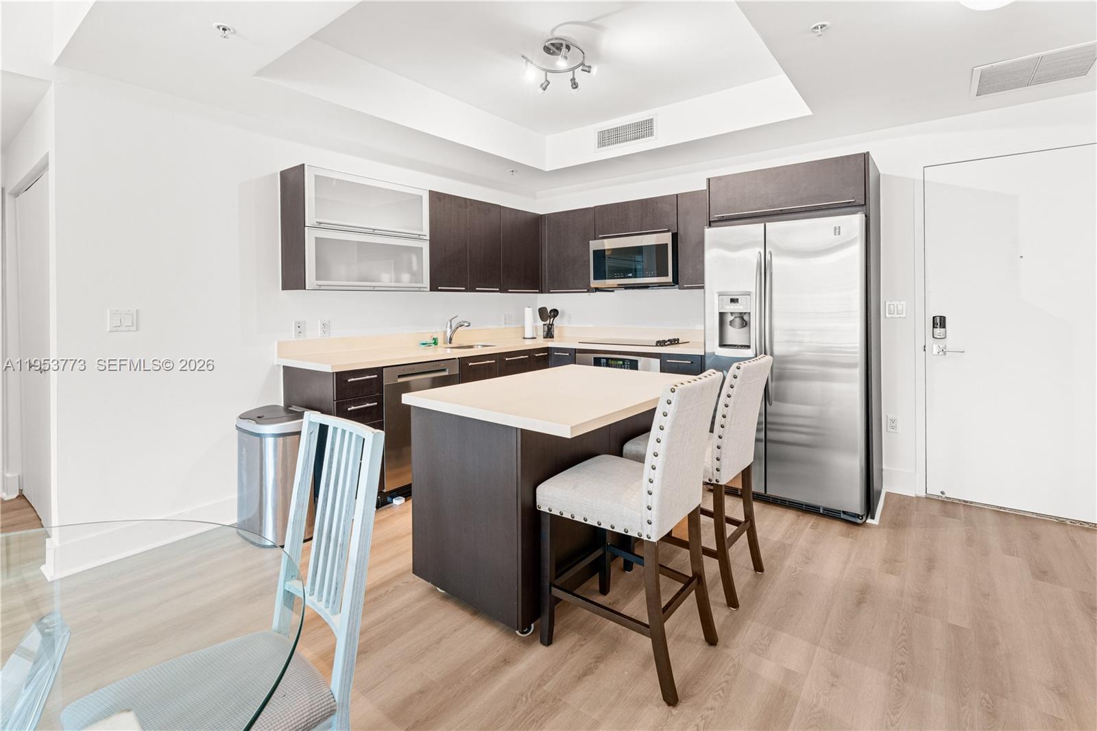 90 Southwest 3rd Street, Unit 1115 Miami, FL 33130 - Photo 3 of 17 a kitchen with stainless steel appliances a microwave a stove a refrigerator a sink a table and chairs