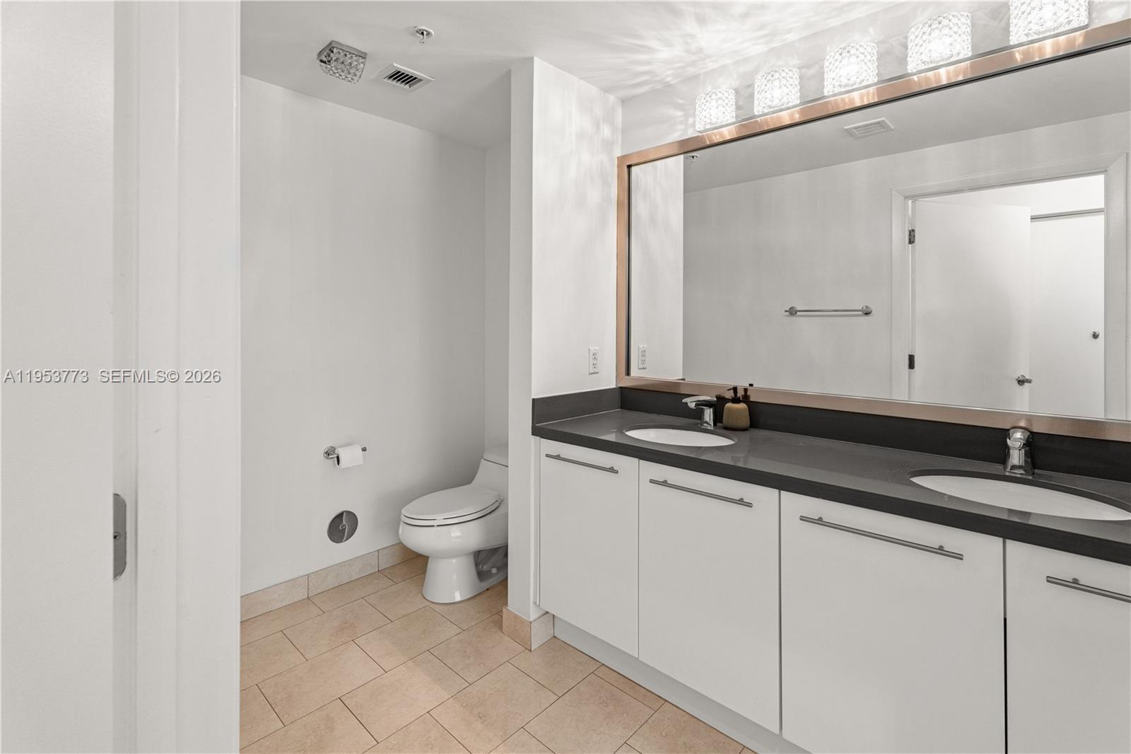 90 Southwest 3rd Street, Unit 1115 Miami, FL 33130 - Photo 6 of 17 a bathroom with a granite countertop sink a toilet and a mirror