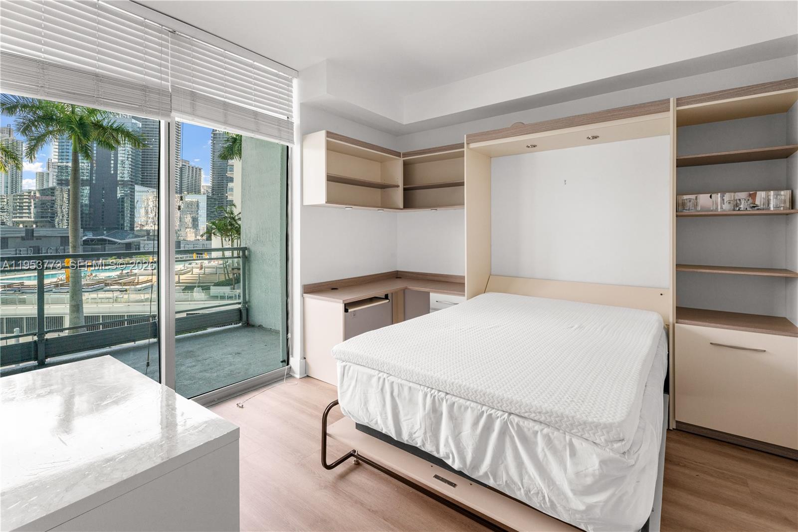 90 Southwest 3rd Street, Unit 1115 Miami, FL 33130 - Photo 10 of 17 a bedroom with a bed and large window with balcony view