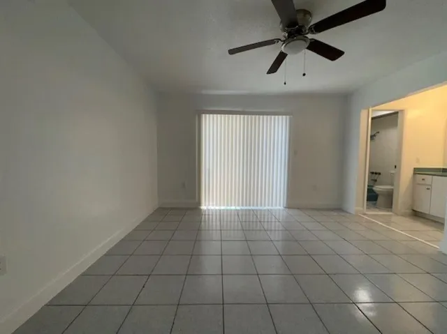 a view of a livingroom with a ceiling fan and window