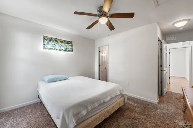 a bedroom with a bed and a ceiling fan