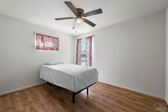 a bedroom with a bed and a ceiling fan