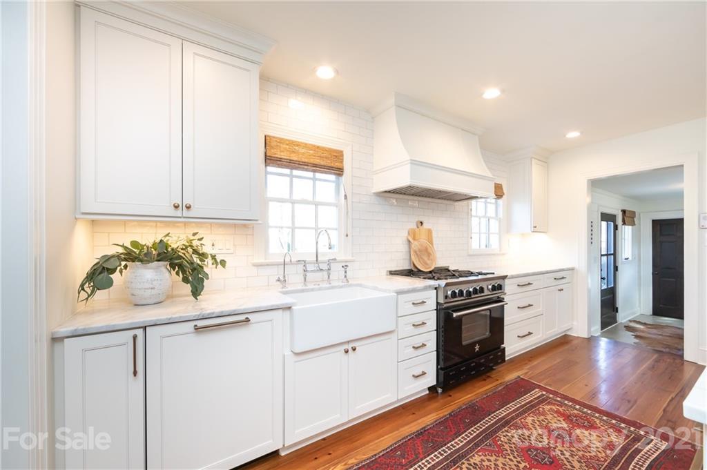 2901 Idlewood Circle Charlotte, NC 28209 - Photo 18 of 48 a kitchen with white cabinets appliances and wooden floor