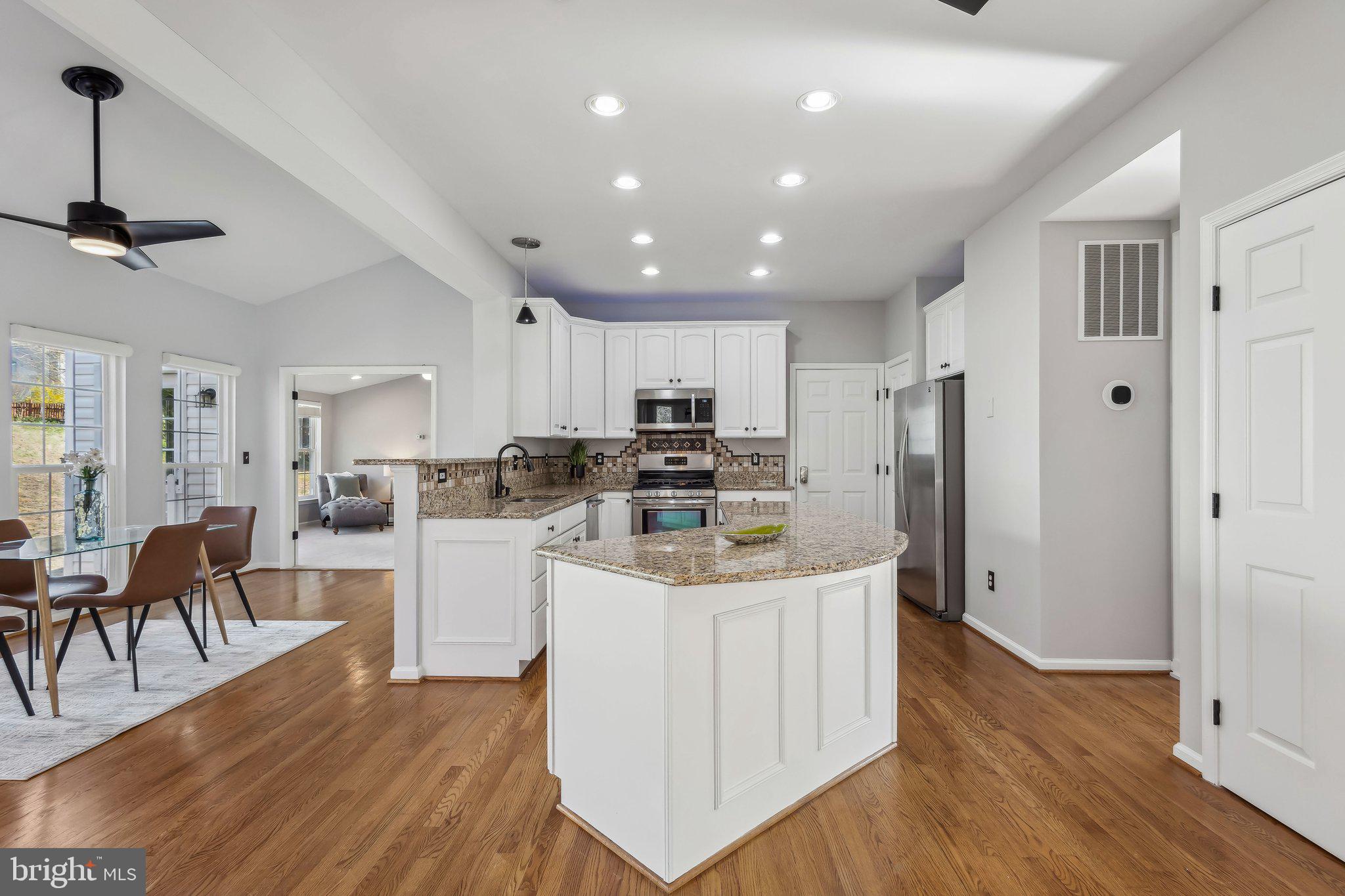 169 Basalt Drive Fredericksburg, VA 22406 - Photo 16 of 56 a kitchen with stainless steel appliances kitchen island granite countertop a refrigerator a stove a sink a dining table and chairs with wooden floor