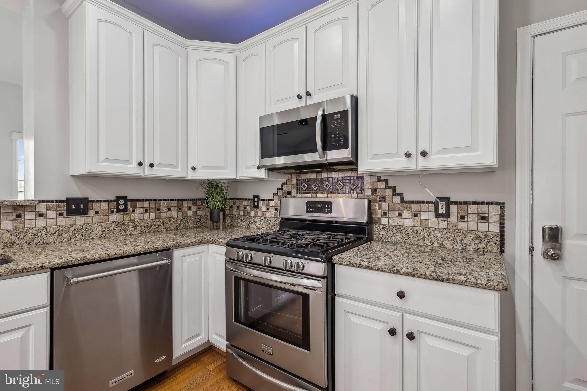 169 Basalt Drive Fredericksburg, VA 22406 - Photo 17 of 56 a kitchen with stainless steel appliances granite countertop a stove a microwave and cabinets