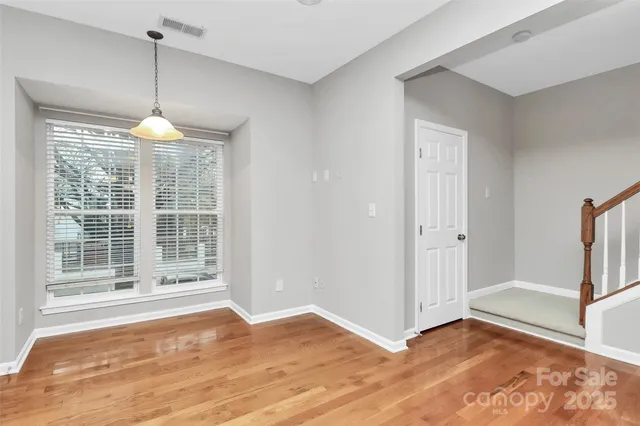 a view of a room with window wooden floor and a chandelier