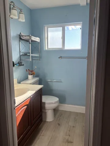 a bathroom with a granite countertop toilet sink and mirror