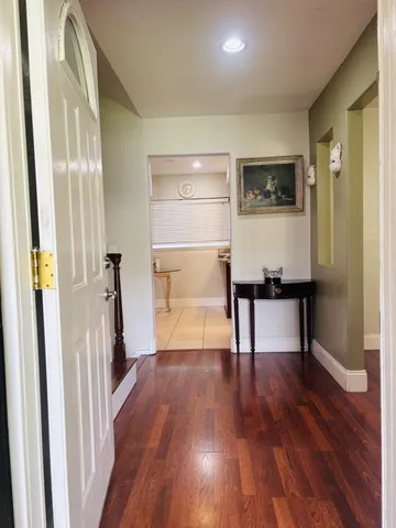 a view of a hallway with wooden floor and staircase