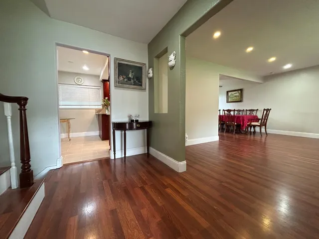 a view of a room with wooden floor chairs a kitchen view and wooden floor