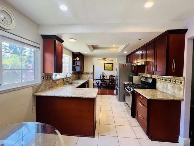 a kitchen with stainless steel appliances granite countertop a sink counter space cabinets and a large window