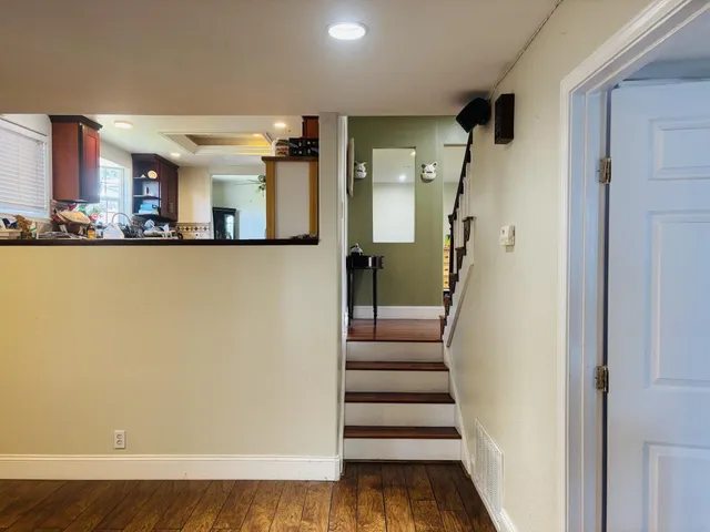 a view of a hallway with wooden floor and staircase