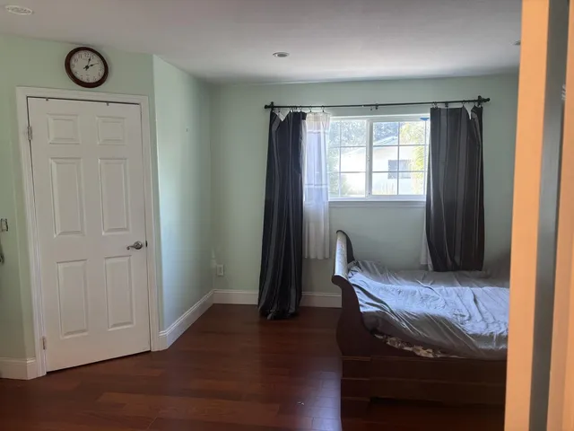 a view of hallway with wooden floor and chair