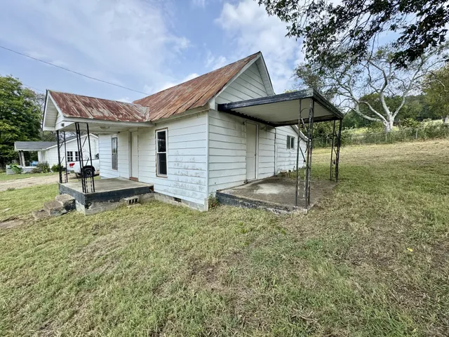 a backyard of a house with table and chairs