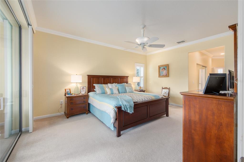 9479 Southwest 71st Loop Ocala, FL 34481 - Photo 17 of 84 a spacious bedroom with a bed and a flat screen tv
