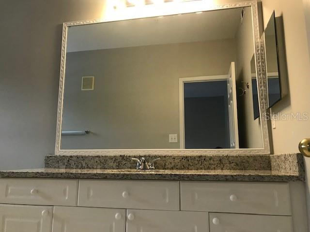 599 Campus Street, Unit 599 Celebration, FL 34747 - Photo 16 of 24 a bathroom with a granite countertop sink and a mirror