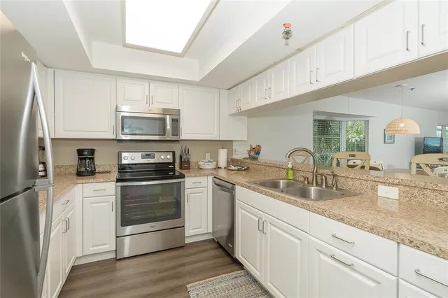 a kitchen with sink a microwave and cabinets
