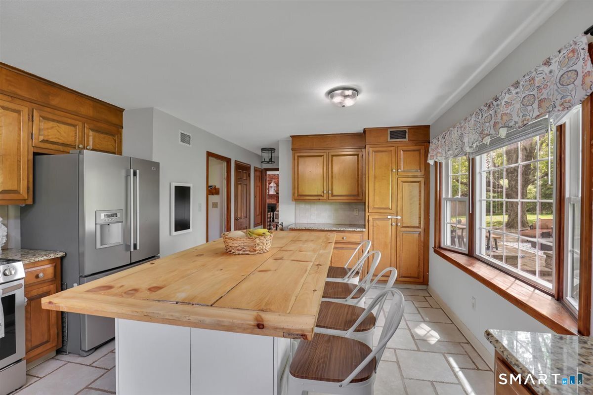 72 Old Post Road Wethersfield, CT 06109 - Photo 10 of 40 a kitchen with stainless steel appliances kitchen island granite countertop a refrigerator and a stove top oven