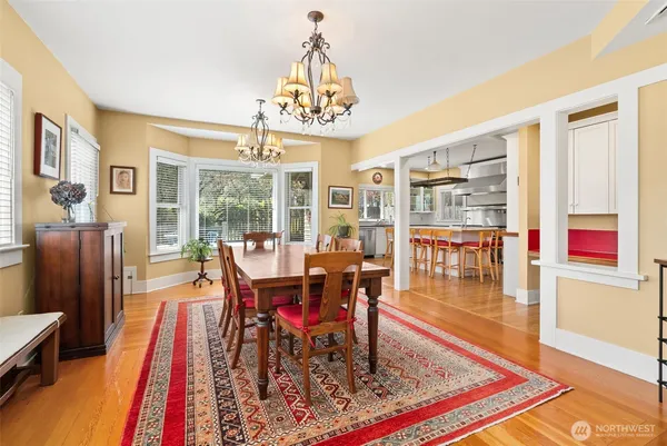 a dining room with wooden floor and large window