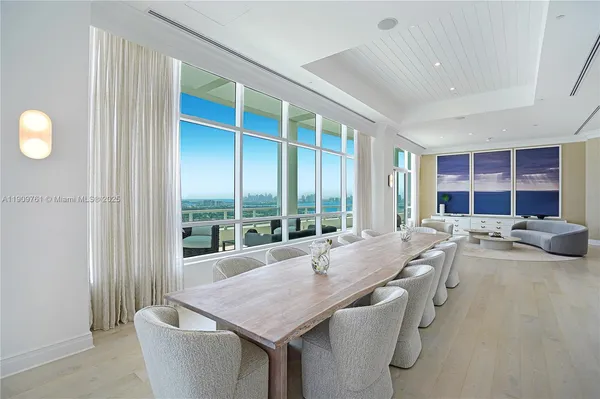 a dining hall with stainless steel appliances granite countertop a kitchen island a stove and a sink
