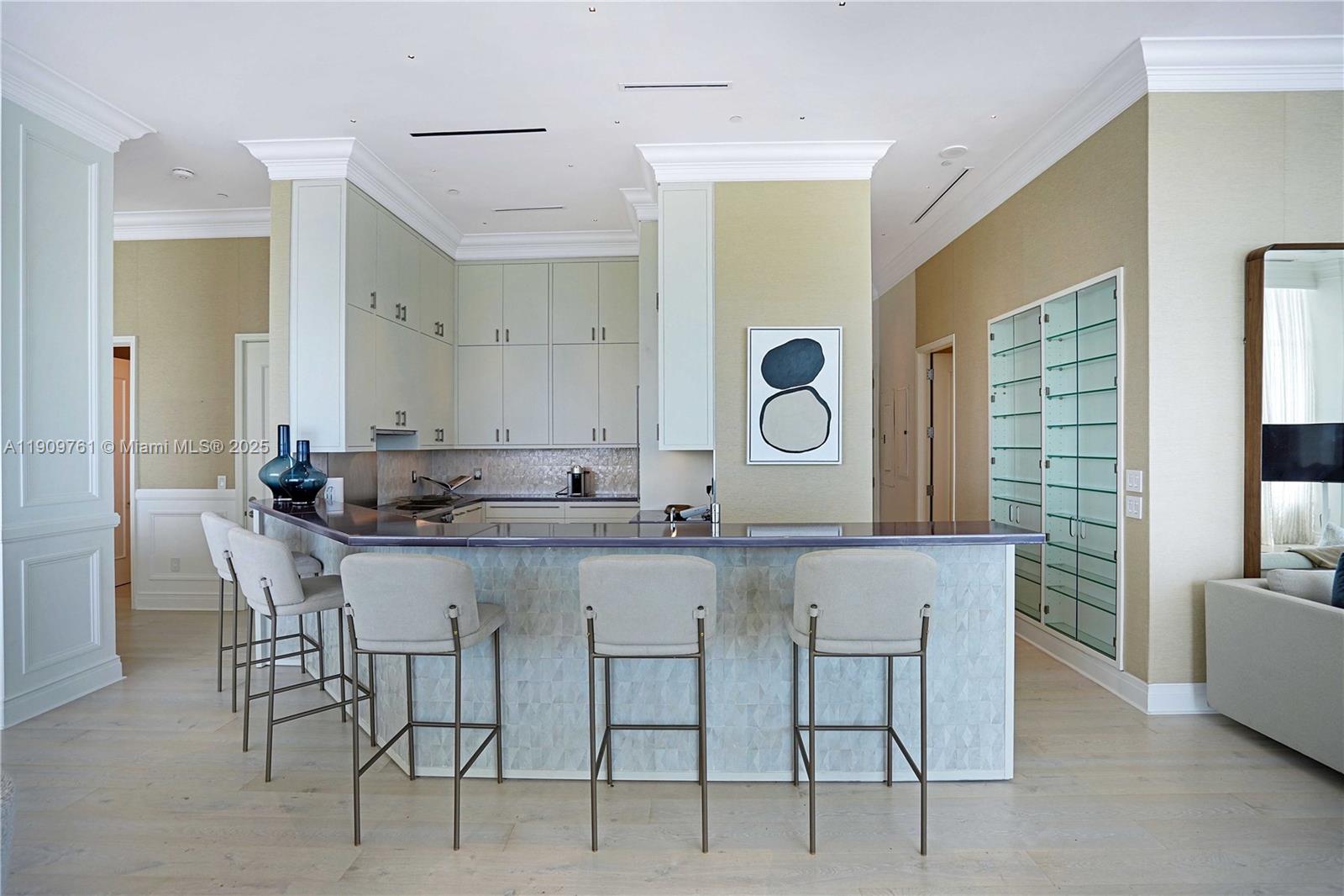 4401 Collins Avenue, Unit PHSOUTH Miami Beach, FL 33140 - Photo 29 of 92 a kitchen with a dining table chairs cabinets and stainless steel appliances