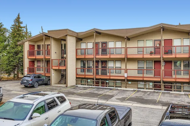 a view of a brick house with many windows next to a road